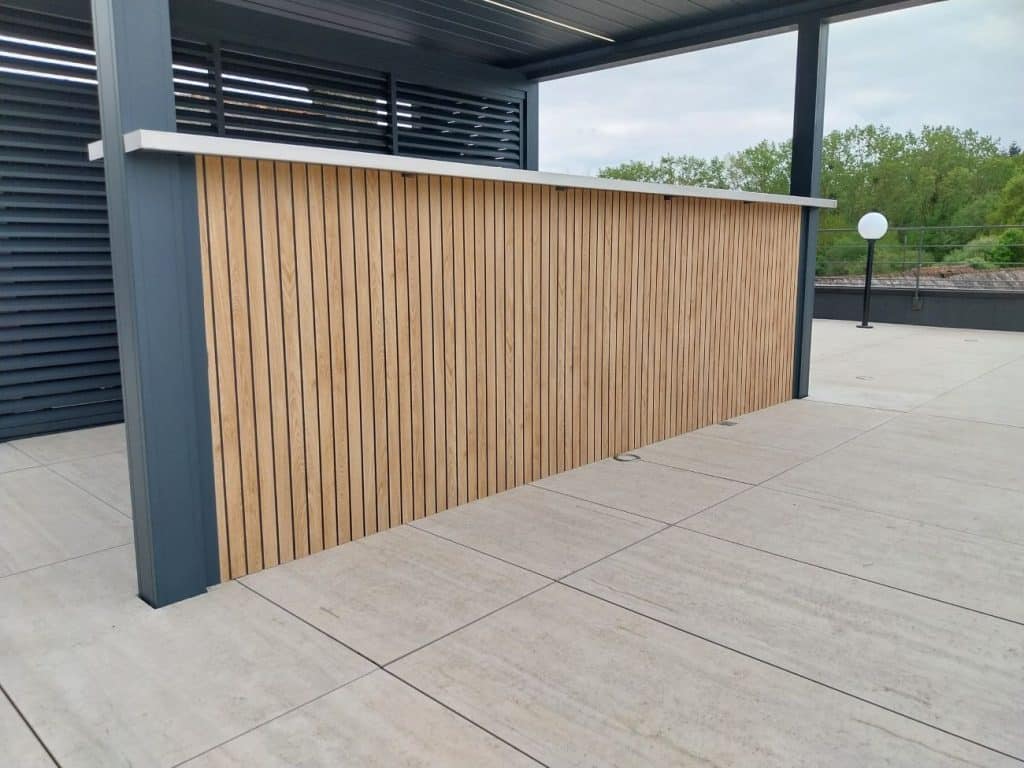 Claustra aluminium Chandon à lames décor bois sur bar extérieur