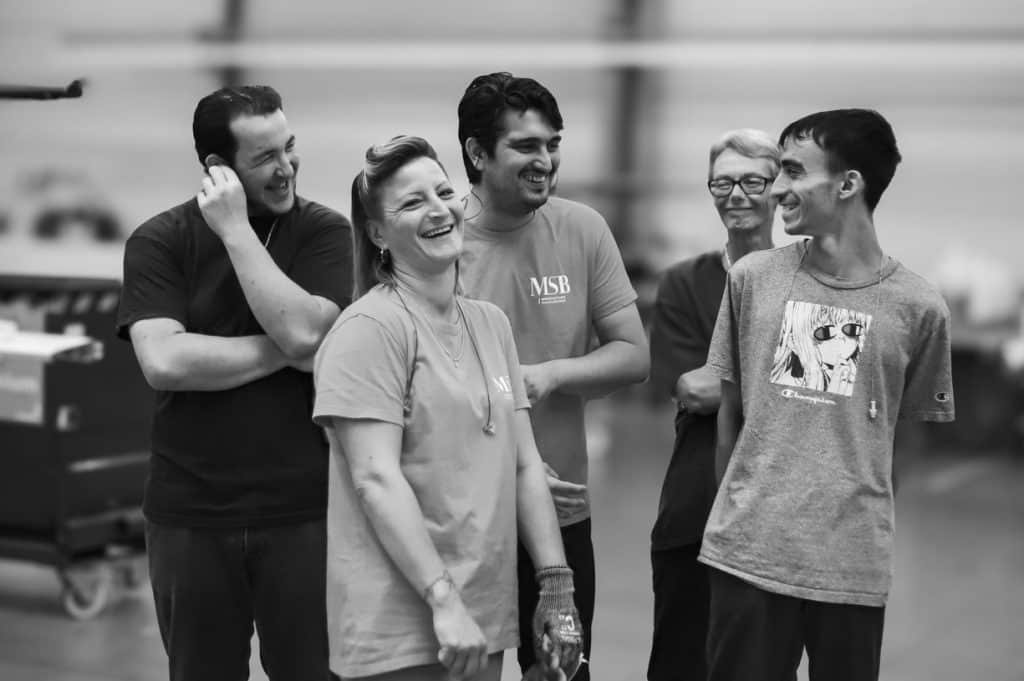 Groupe de collaborateurs souriants sur le site de production COUBLANC