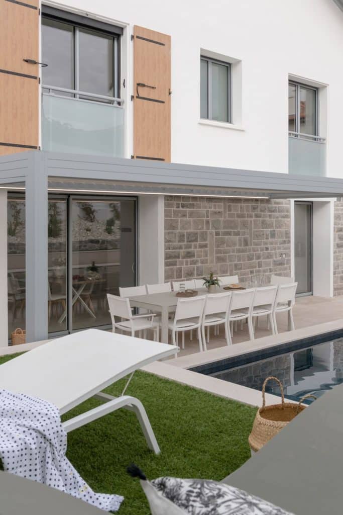 Vue latérale sur la pergola Hauteval installée sur la façade d'une maison contemporaine